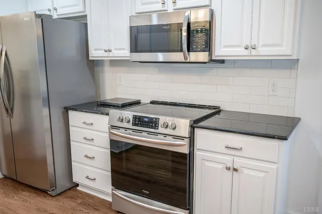 a kitchen with stainless steel appliances white cabinets and a stove