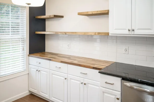 a kitchen with white cabinets and a wooden floor