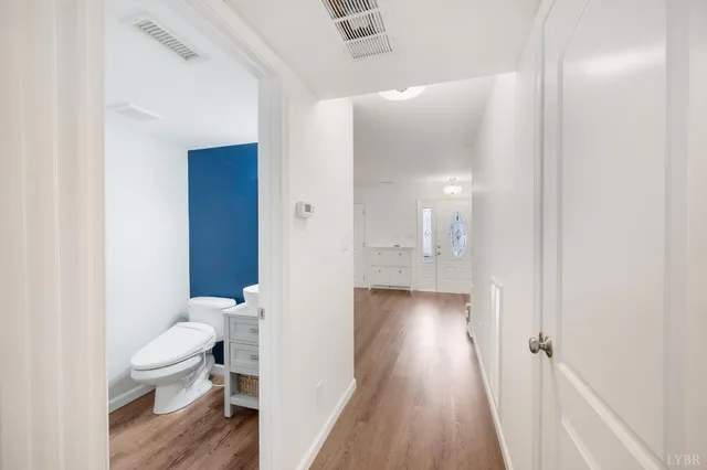 a bathroom with a toilet and a hardwood