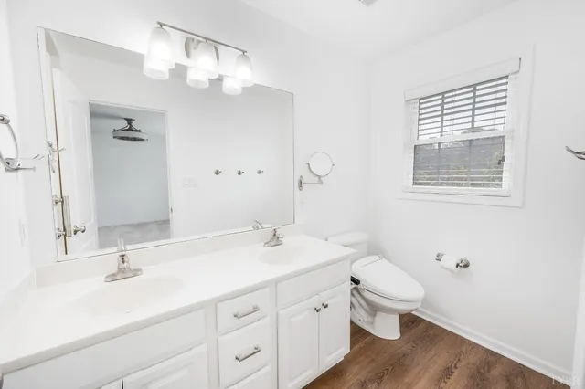 a bathroom with a double vanity sink a toilet and a mirror