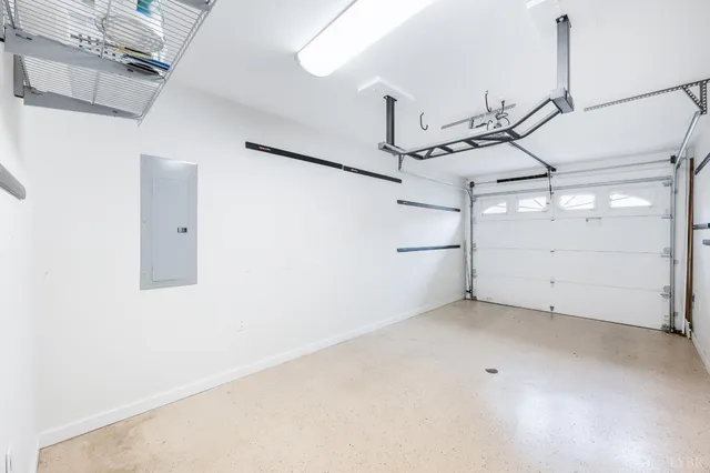 a view of a white house with a big yard plants and large trees