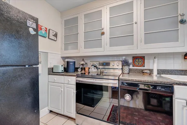 a kitchen with stainless steel appliances granite countertop a refrigerator and a stove