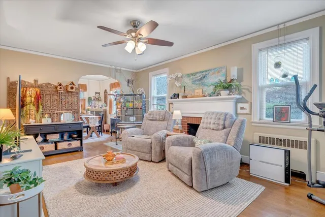 a living room with furniture fireplace and a large window