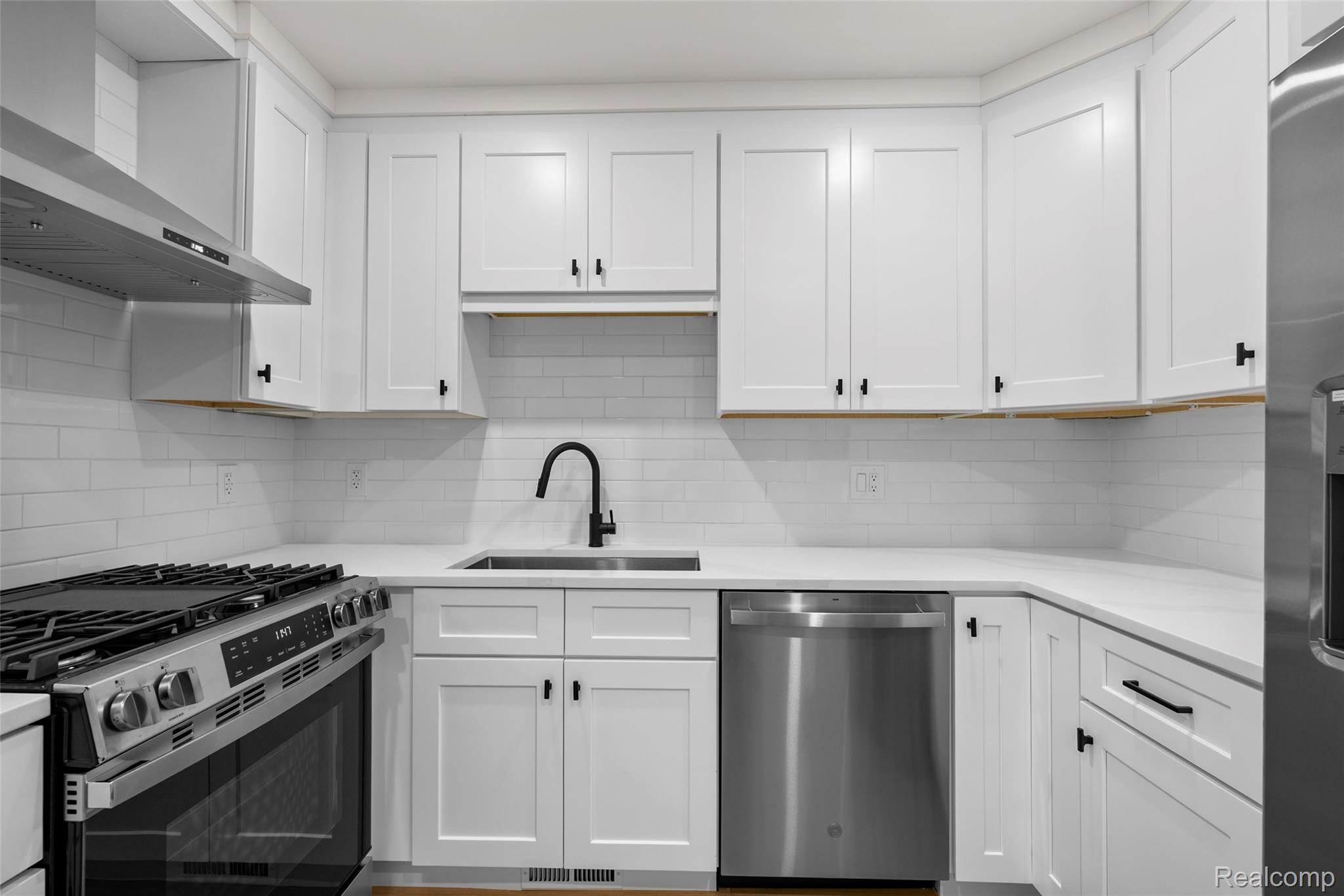 1830 Streamedge Court Rochester, MI 48309 - Photo 13 of 33 White shaker-style cabinetry with matte black hardware, stainless steel appliances, and white subway tile backsplash