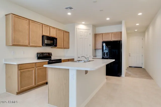 a kitchen with stainless steel appliances granite countertop a sink a stove and a refrigerator