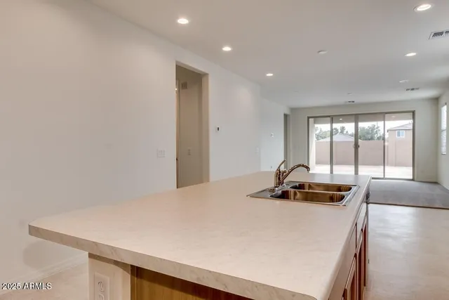 a room with a bed a couch and a view of kitchen