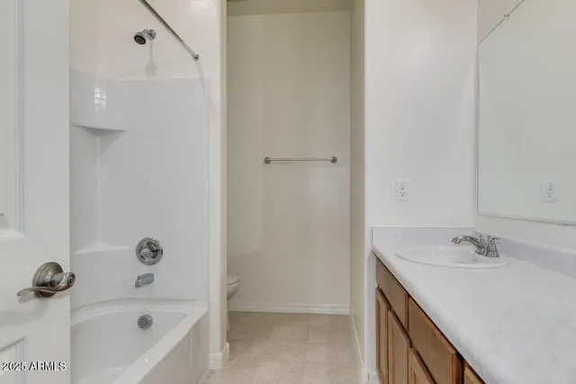 a bathroom with a tub sink vanity and mirror