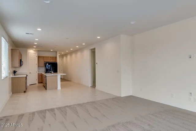 a view of kitchen with kitchen island a sink white cabinets and white appliances