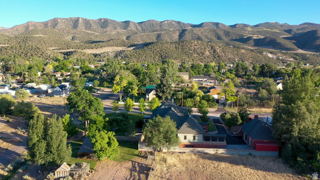 426 West Center Street Parowan, UT 84761 - Photo 101 of 107 Expansive property featuring a central residence with a gabled roof, an attached red-sided structure, and surrounding mature trees