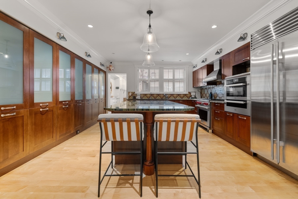 321 Beacon Street Boston, MA 02116 - Photo 17 of 34 a kitchen with stainless steel appliances granite countertop a kitchen island hardwood floor sink stove dining table and chairs