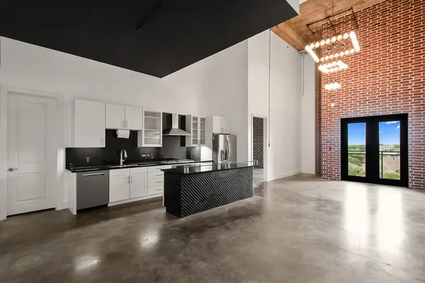 a large white kitchen with stainless steel appliances granite countertop a stove and a refrigerator