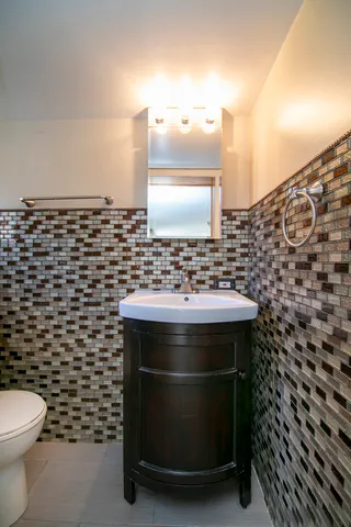 a bathroom with a sink a toilet and a mirror