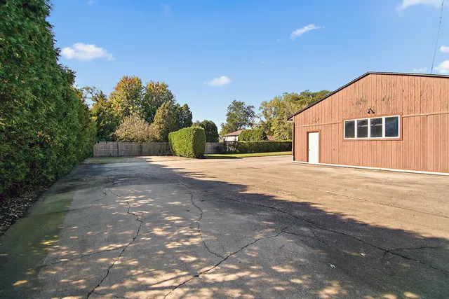 a view of an house with backyard and trees