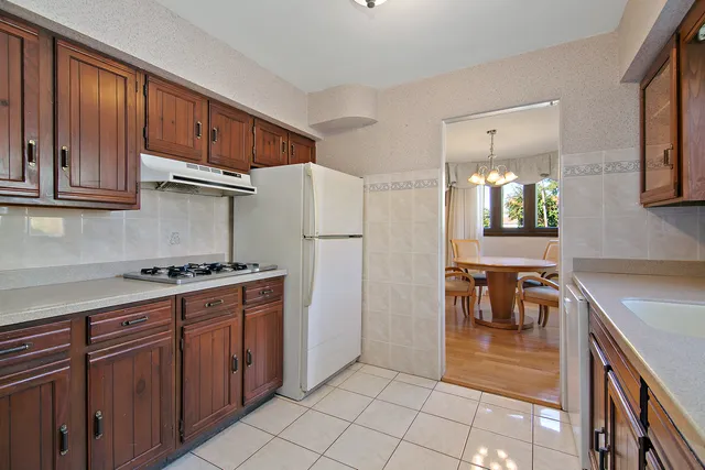 a kitchen with stainless steel appliances granite countertop a refrigerator and a stove top oven