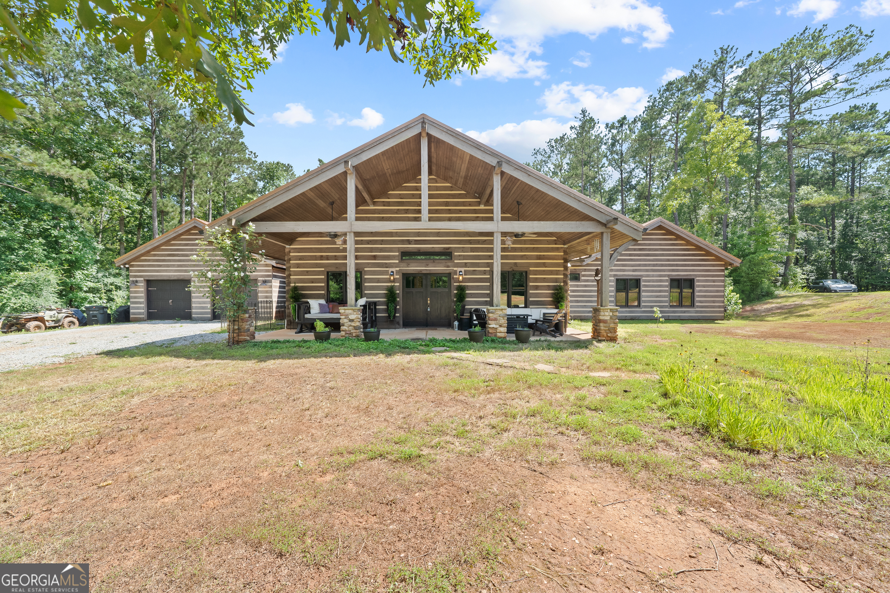 a front view of house with yard and trees in the background
