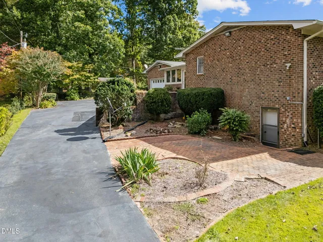 a view of a house with a yard and potted plants