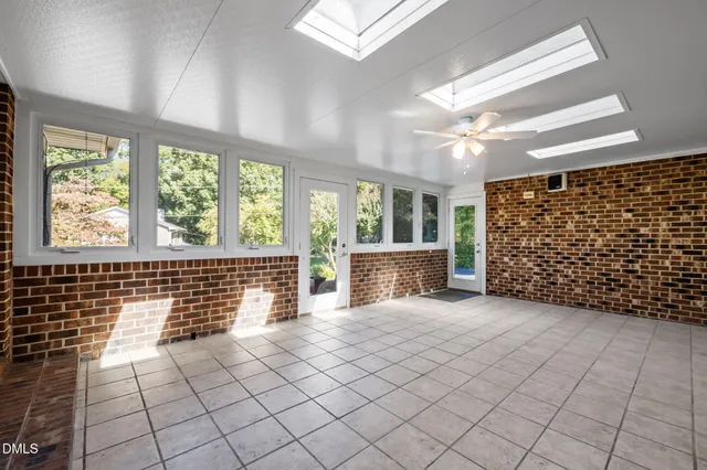 a view of a big room with windows and ceiling fan