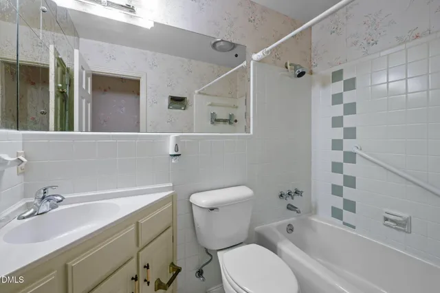 a bathroom with a granite countertop sink a toilet and a mirror
