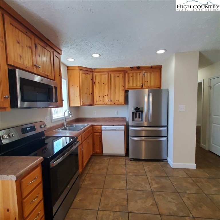 161 Alexander Drive Boone, NC 28607 - Photo 8 of 28 a kitchen with a sink stainless steel appliances and cabinets