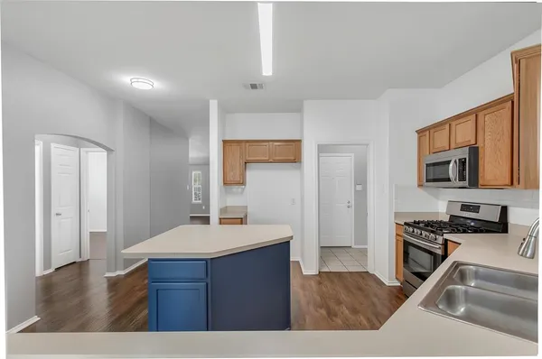 a kitchen with kitchen island a sink stainless steel appliances and cabinets