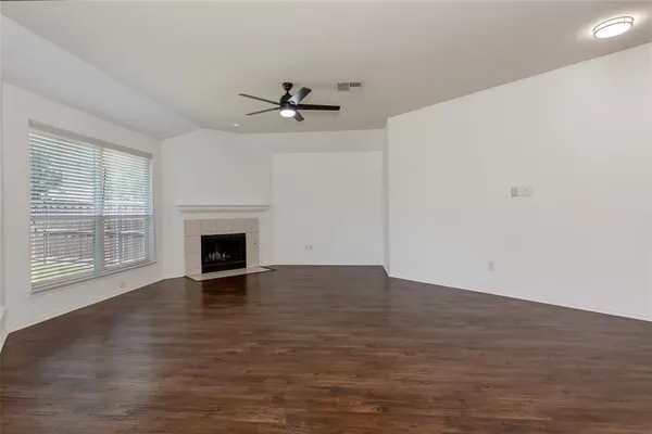 a view of empty room with wooden floor and fireplace