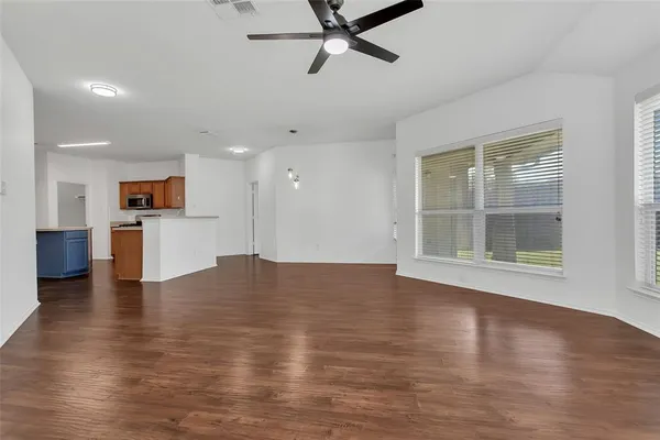 a view of empty room with wooden floor and windows
