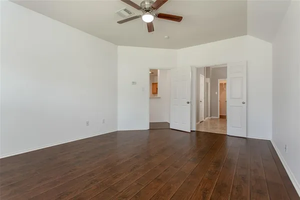 a view of an empty room with wooden floor