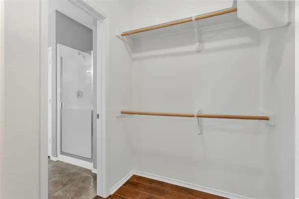 an empty room with wooden floor ceiling fan and windows