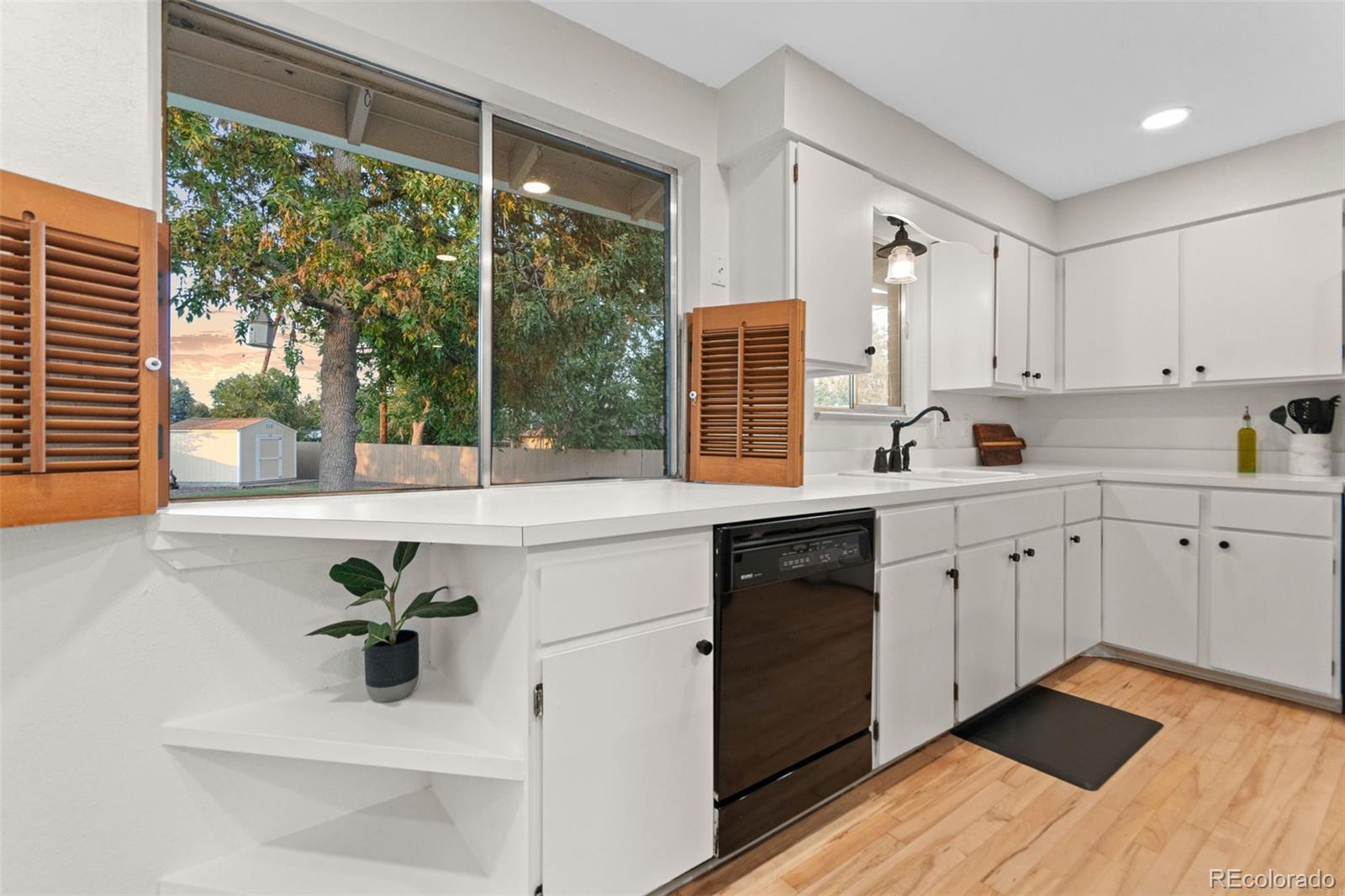 5366 Field Circle Arvada, CO 80002 - Photo 16 of 50 a kitchen with a sink windows and white cabinets