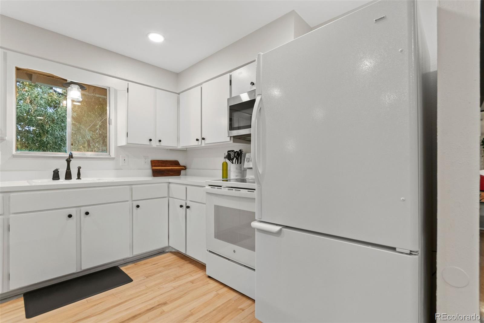 5366 Field Circle Arvada, CO 80002 - Photo 19 of 50 a kitchen with white cabinets and white appliances