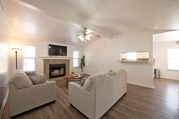 a living room with furniture a fireplace and a flat screen tv