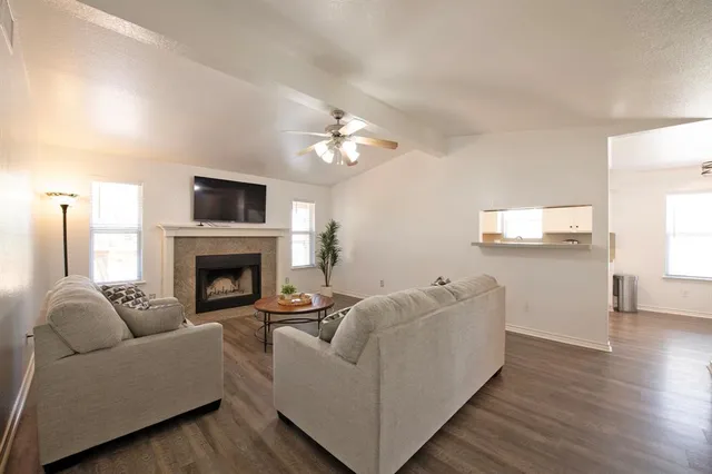a living room with furniture a fireplace and a flat screen tv
