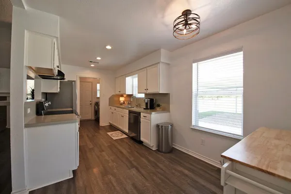a kitchen with refrigerator cabinets and wooden floor