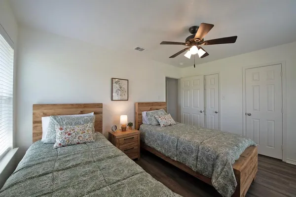 a bedroom with two beds and a chandelier