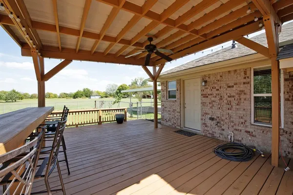 a view of a patio with dining table and chairs with wooden floor