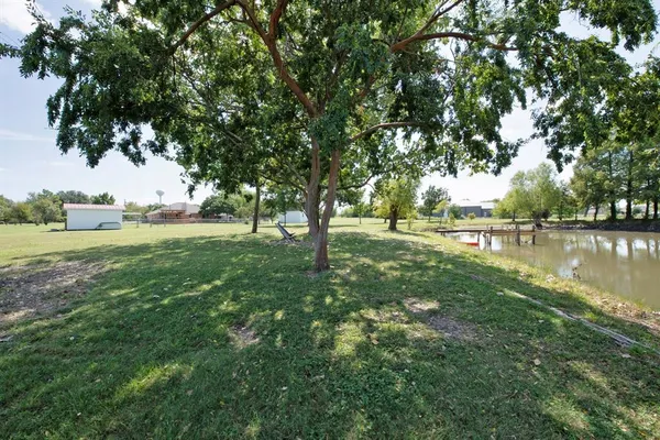 a view of green field with trees in the background