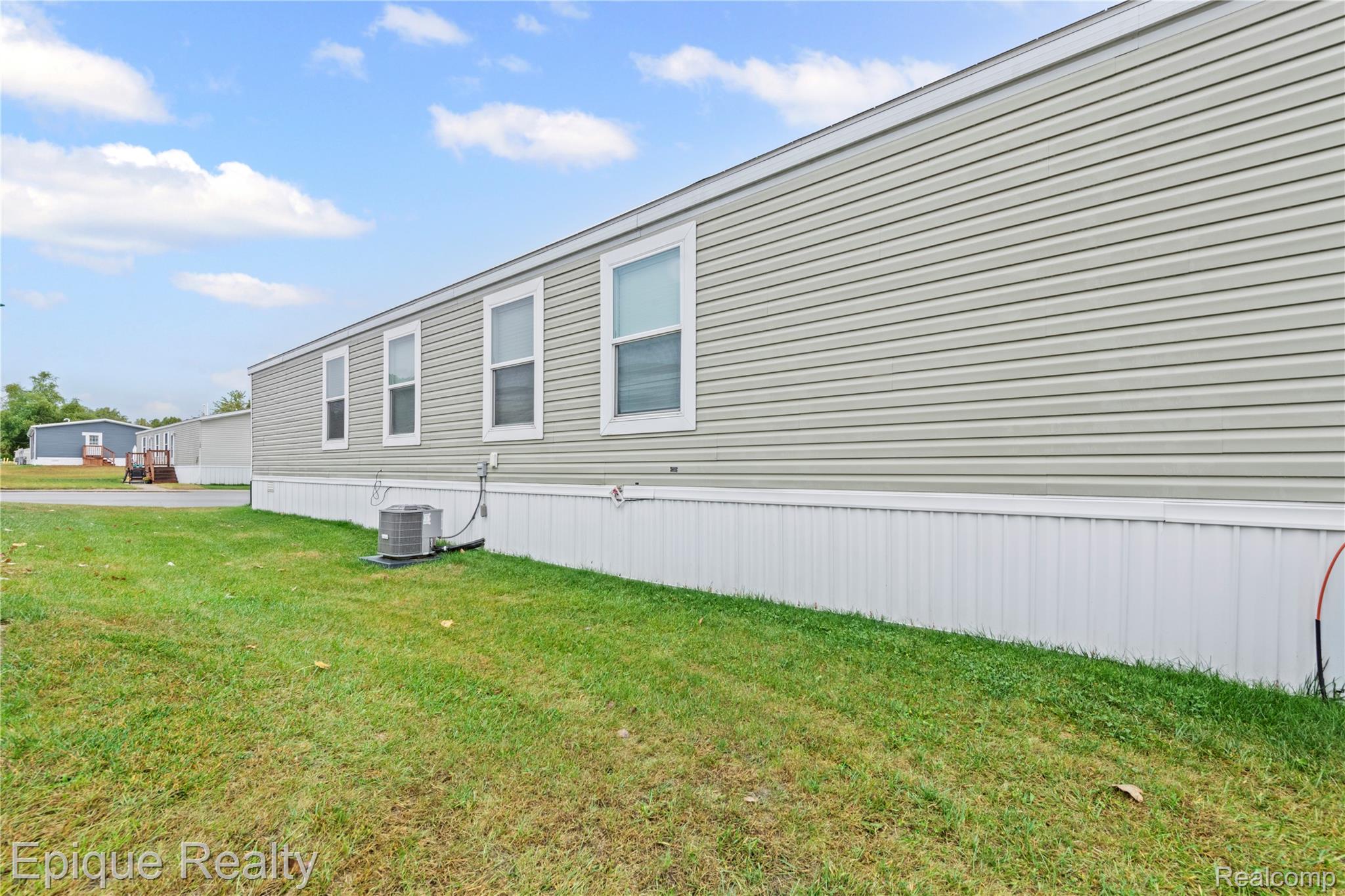 83 Elm Highland, MI 48357 - Photo 5 of 27 View of home's exterior featuring a lawn
