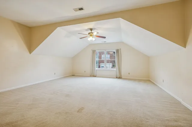 an empty room with windows and chandelier fan