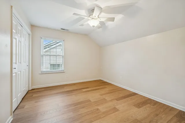 an empty room with windows and fan