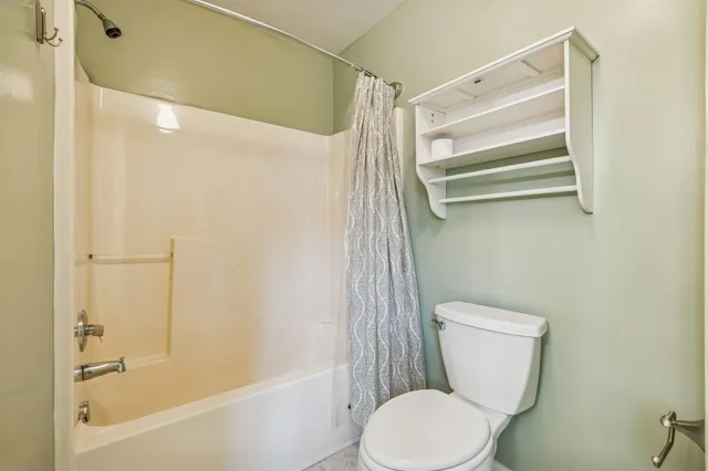 a white toilet sitting next to a bath tub