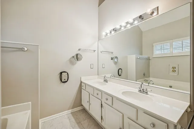 a spacious bathroom with a double vanity sink a mirror and shower