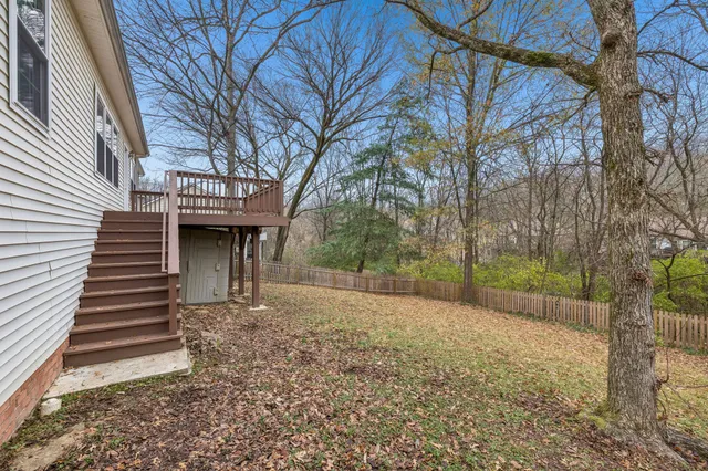 a view of a house with backyard and trees
