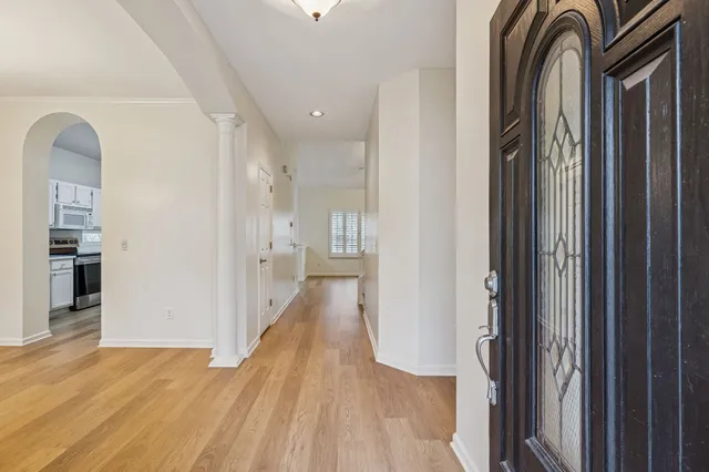 a view of a hallway with wooden floor and staircase