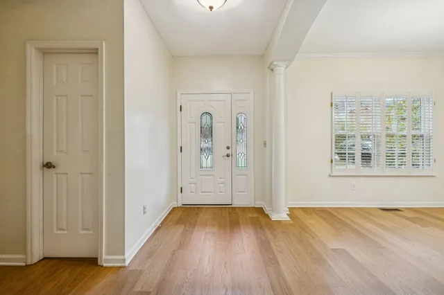an empty room with wooden floor and windows