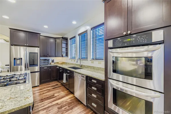 a kitchen with stainless steel appliances granite countertop a stove a sink and a microwave