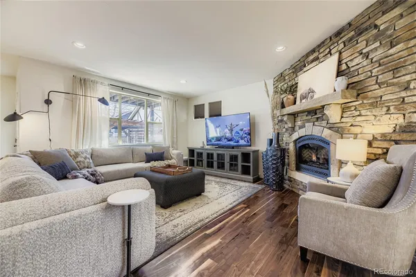 a living room with furniture a fireplace and a flat screen tv