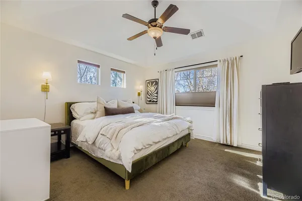 a spacious bedroom with a bed and a chandelier