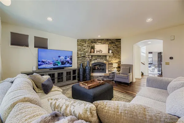 a living room with furniture a flat screen tv and a fireplace