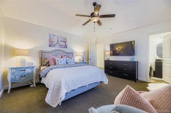 a spacious bedroom with a bed and a flat screen tv