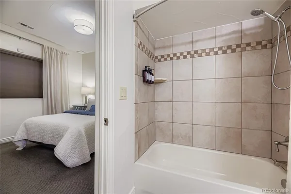 a bathroom with a tub shower and vanity